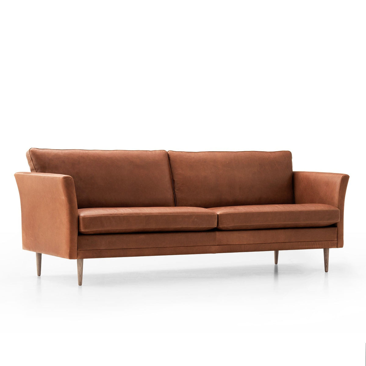 A mid-century modern two-seater sofa upholstered in warm cognac brown leather, featuring tapered wooden legs, shown against a seamless white background.