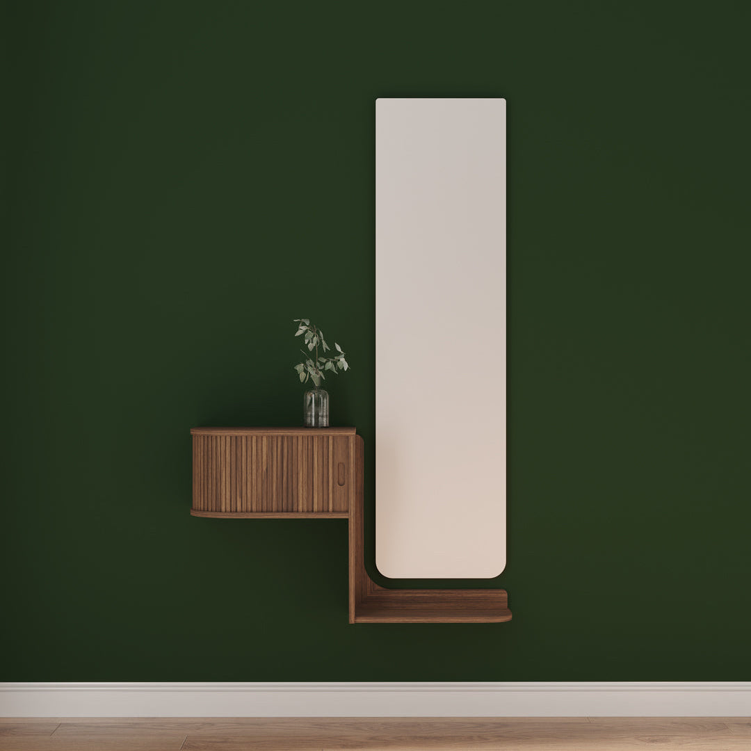 Tall mirror leaning against a green wall with a wooden side table below.