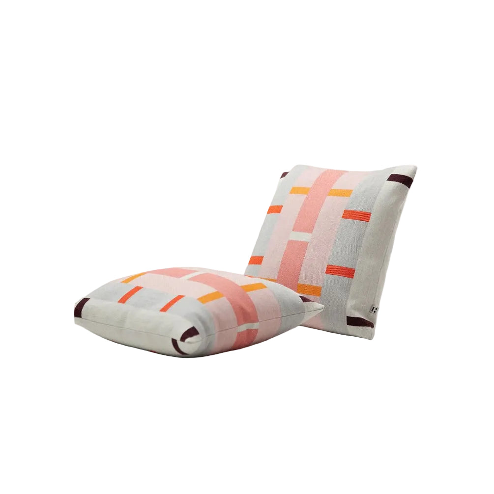 Two square throw pillows with a modern geometric pattern in pink, orange, and dark brown on a light gray linen background, displayed on a clean white surface.