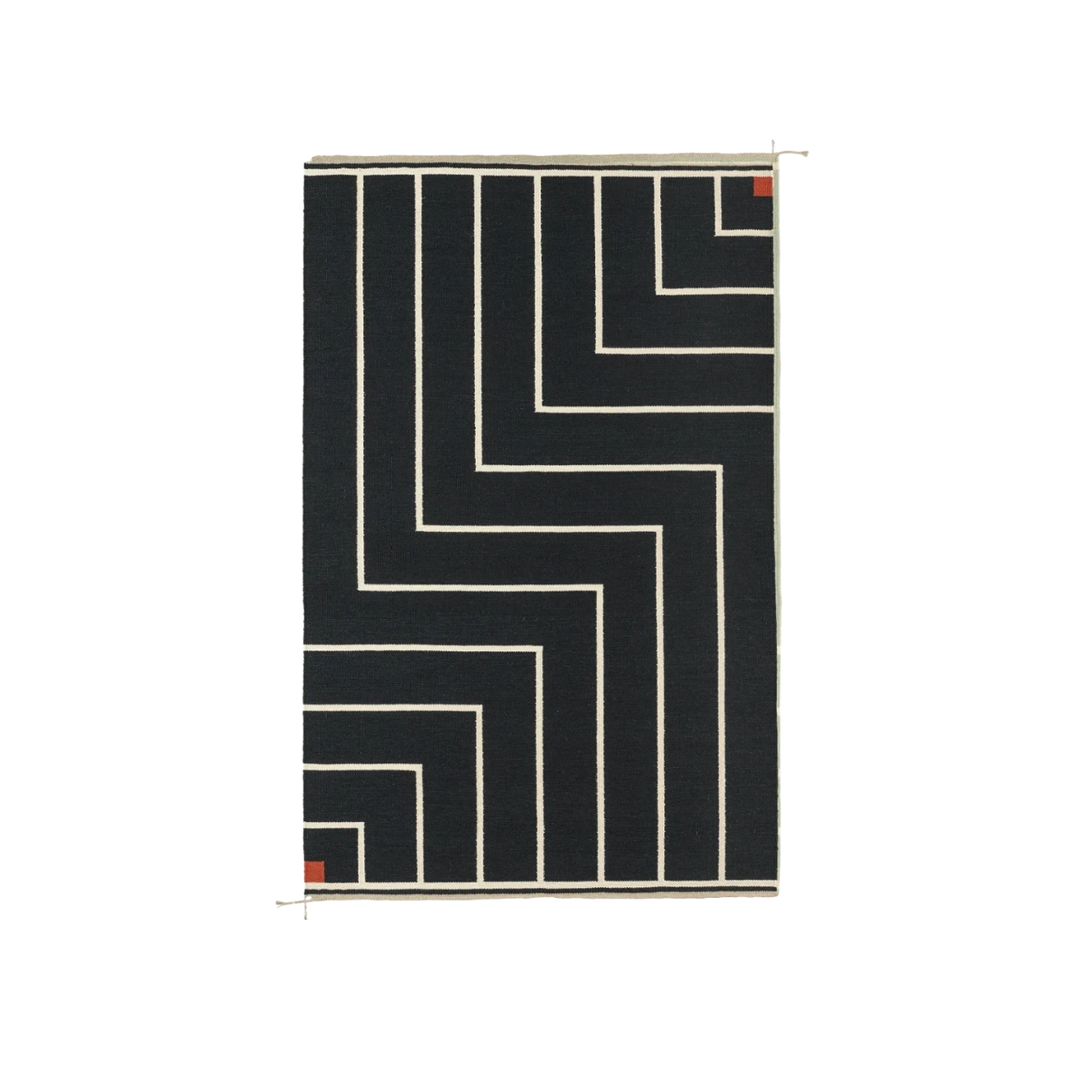 A rectangular black rug with a cream geometric maze-like line pattern and small red square accents in the corners, shown against a plain white background.