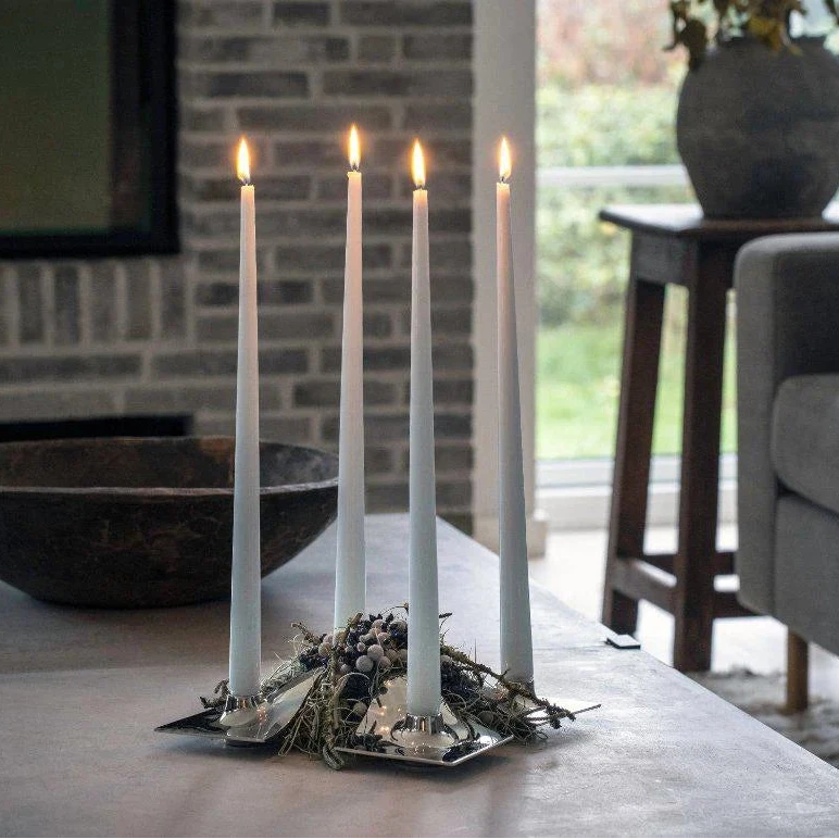 Candle holder with lit candles on a coffee table in a living room setting.